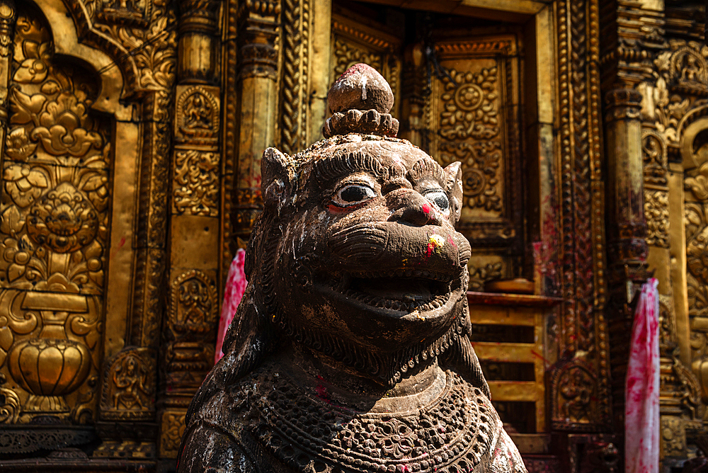 Stone lion guardian statue with intricate carvings at the entrance of Changu Narayan Temple, a UNESCO World Heritage Site in Nepal