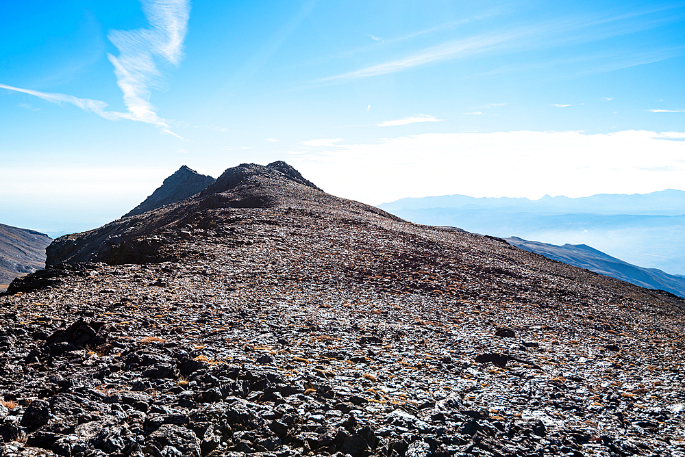 rugged summit ridge of Pico del Caballo under a clear sky in the Sierra Nevada mountains, Andalusia, Spain.