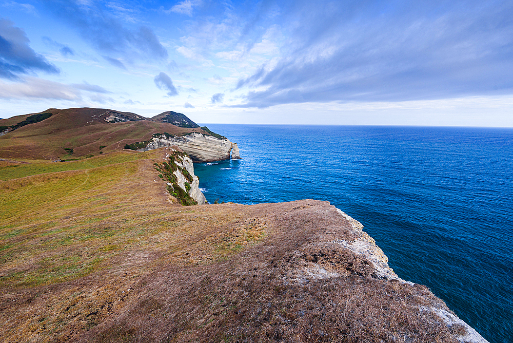 Panoramic view of the steep headlands and turquoise Tasman Sea at Cape Farewell, the northern tip of the South Island, New Zealand. Puponga Farm Park
