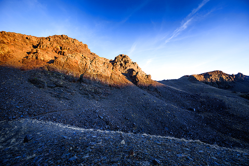 Jagged evening-lit ridges above the glacial cirques of Cerro del Caballo in the Sierra Nevada National Park, Andalusia, Spain.