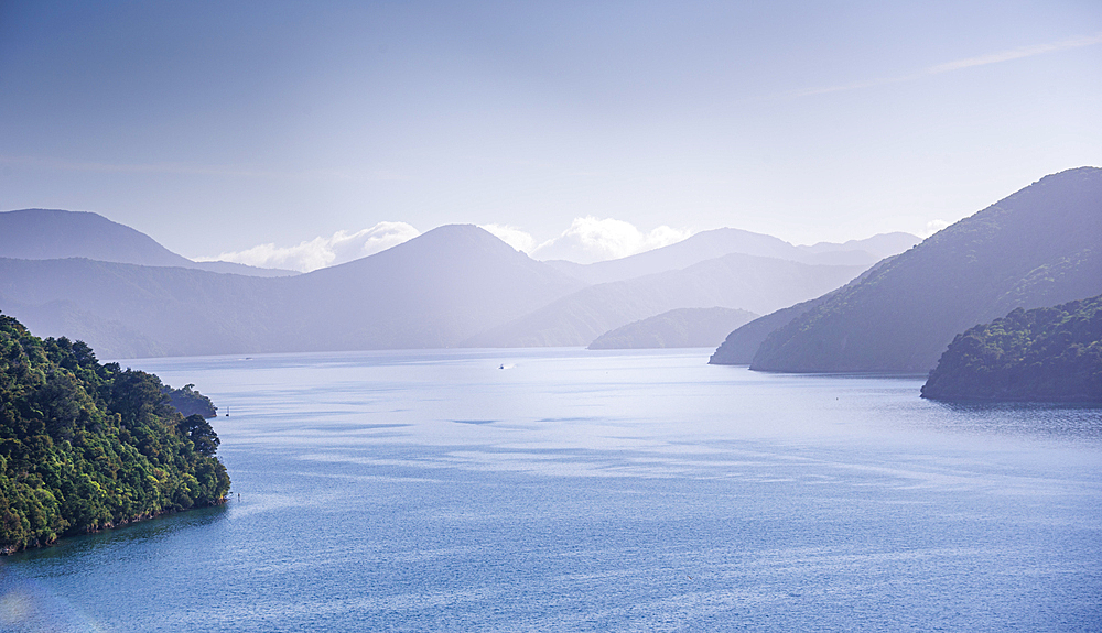 Peaceful dawn scene over Marlborough Sounds, a coastal region of South Island, New Zealand, with misty bays and mountains.