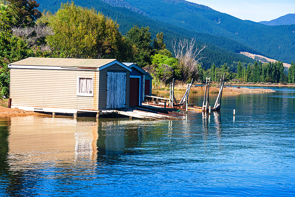 Classic wooden boathouse sits on the shoreline of Marlborough Sounds, a famous boating region in South Island, New Zealand.