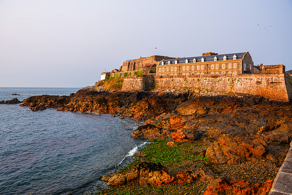 Historic Castle Cornet fortress stands on coastal rocks guarding St Peter Port at low tide, Guernsey, Channel Islands.
