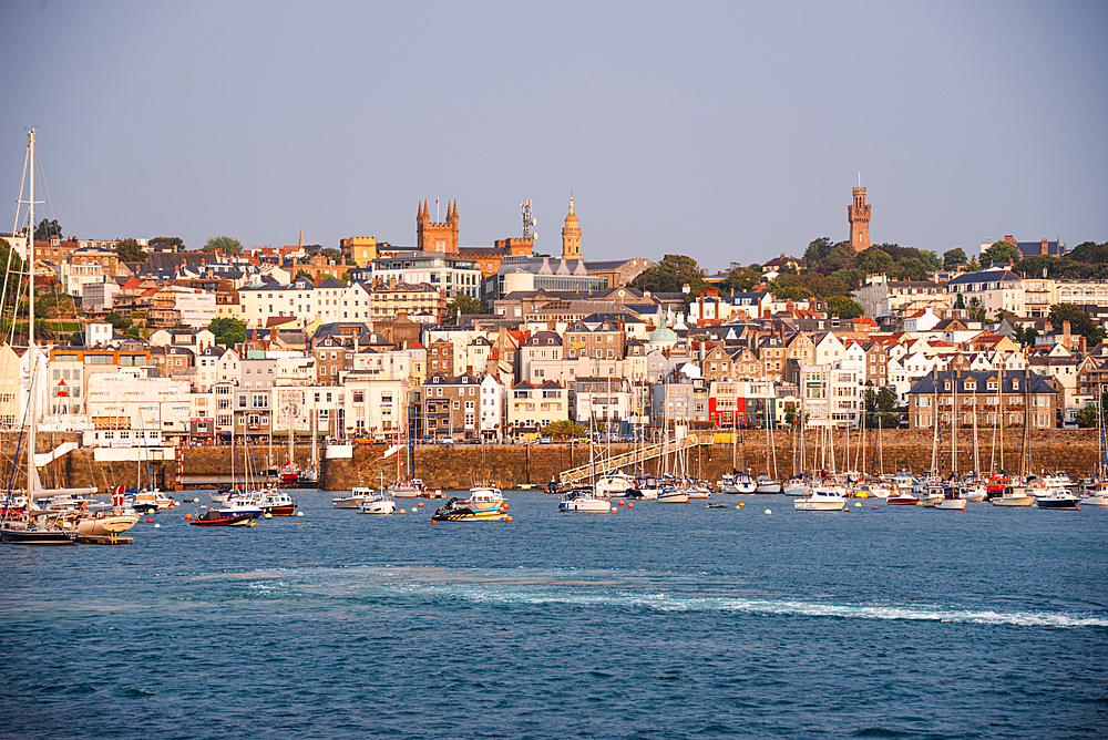 Waterfront view of St Peter Port, Guernsey, Channel Islands, with boats moored in the harbor in tranquil morning light