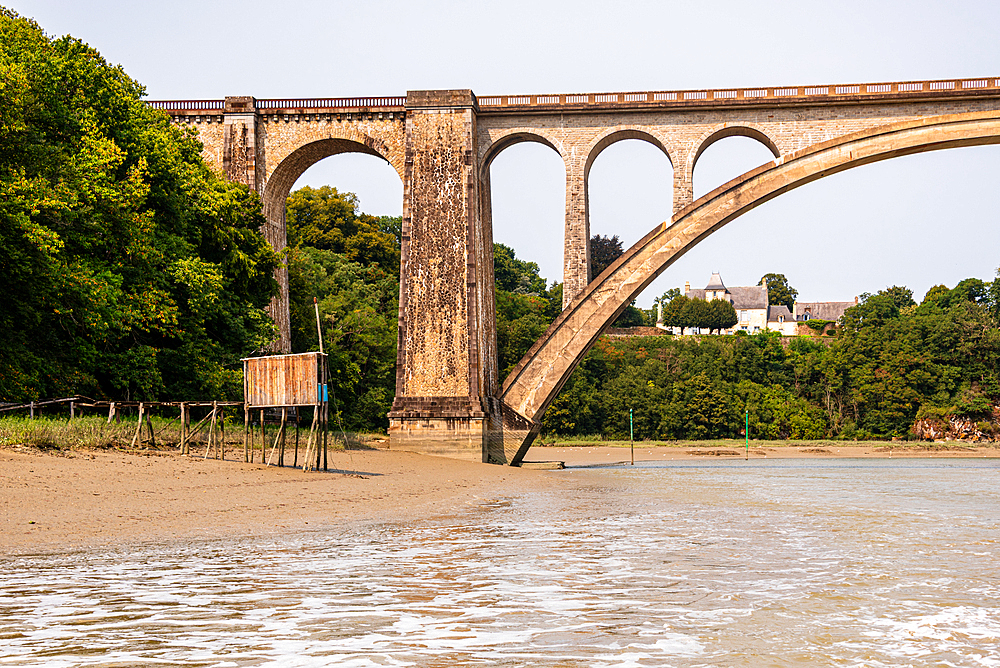 The historic Viaduc de Lessard railway bridge with elegant arches spanning the River Rance near Dinan, Brittany, France.