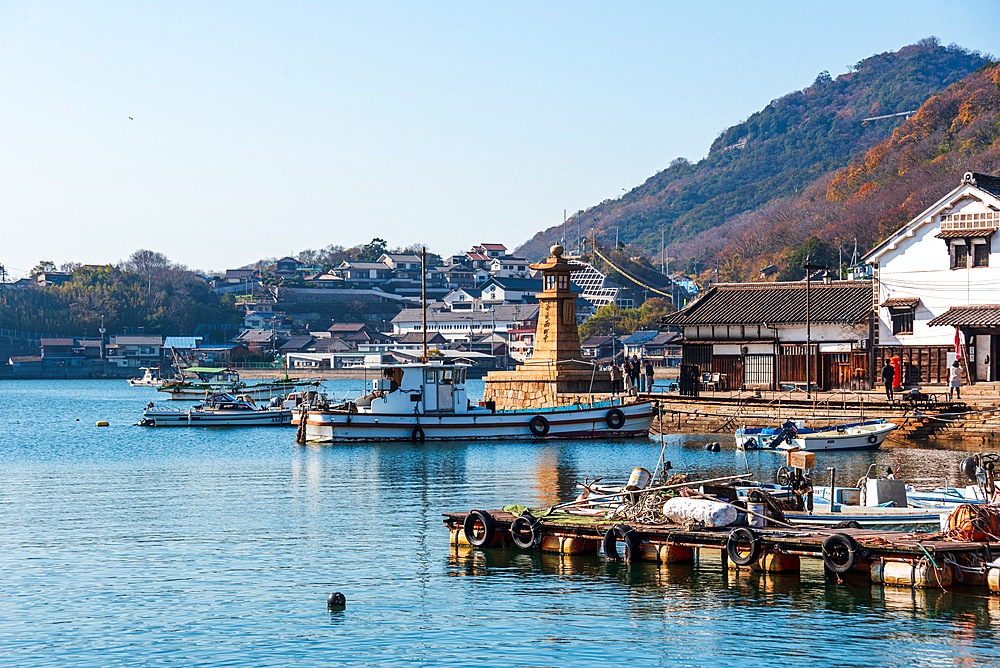 View over the small fishing harbor of Tomonoura with famous stone lighthouse and the blue waters, Tomonoura, Honshu, Japan, Asia