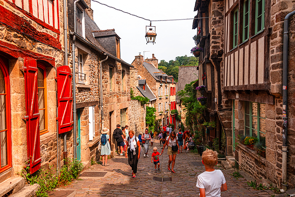 Lively Rue du Jerzual cobbled street with tourists and half-timbered houses in Dinan Brittany France