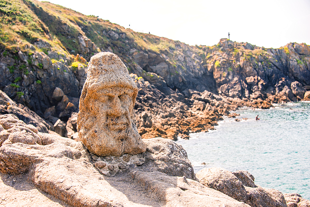 sculpted stone face on coastal rocks overlooking sea near Saint-Malo Brittany France