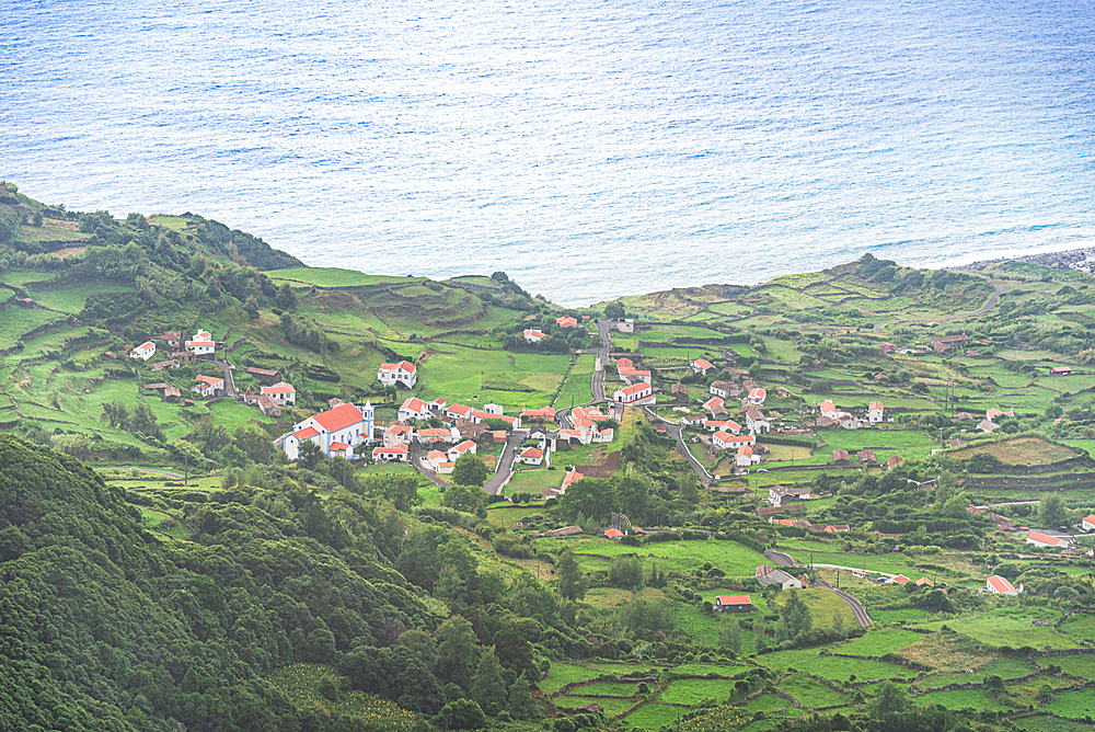 Scenic view of Fajãzinha, a small coastal village surrounded by the Atlantic Ocean and steep green cliffs, Flores Island, Azores, Portugal.