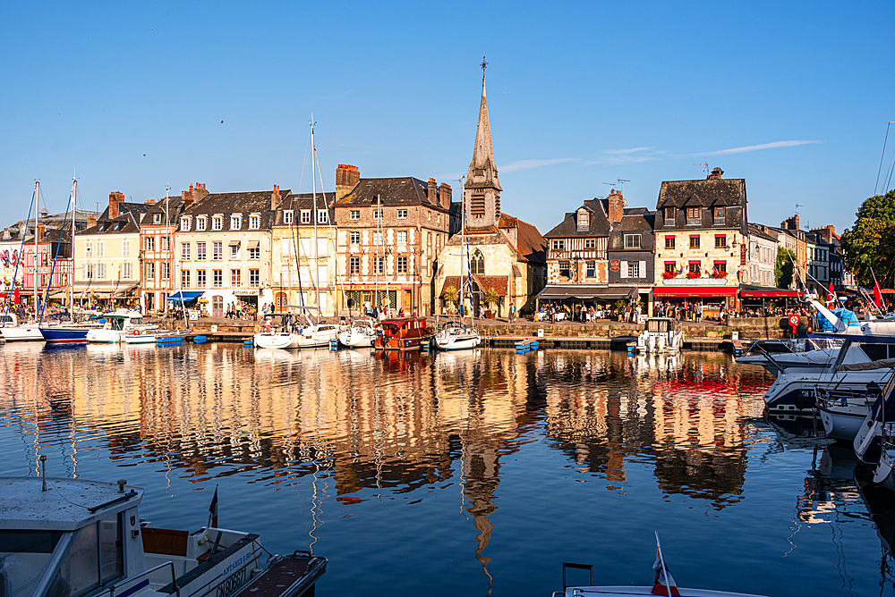 Calm morning reflections of historic buildings in the waters of the Vieux Bassin, Honfleur, Normandy, France.