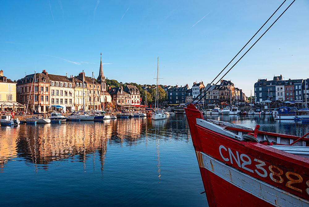 Panoramic view of the Vieux Bassin, Honfleur’s historic harbor, with reflections of boats and medieval buildings on the calm water.
