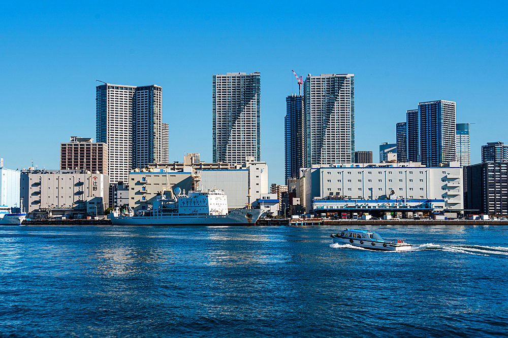 Motorboat in front of skyscrapers of Tokyo Skyline, waterfront in Habor of Harumi district, Tokyo, Honshu, Japan, Asia