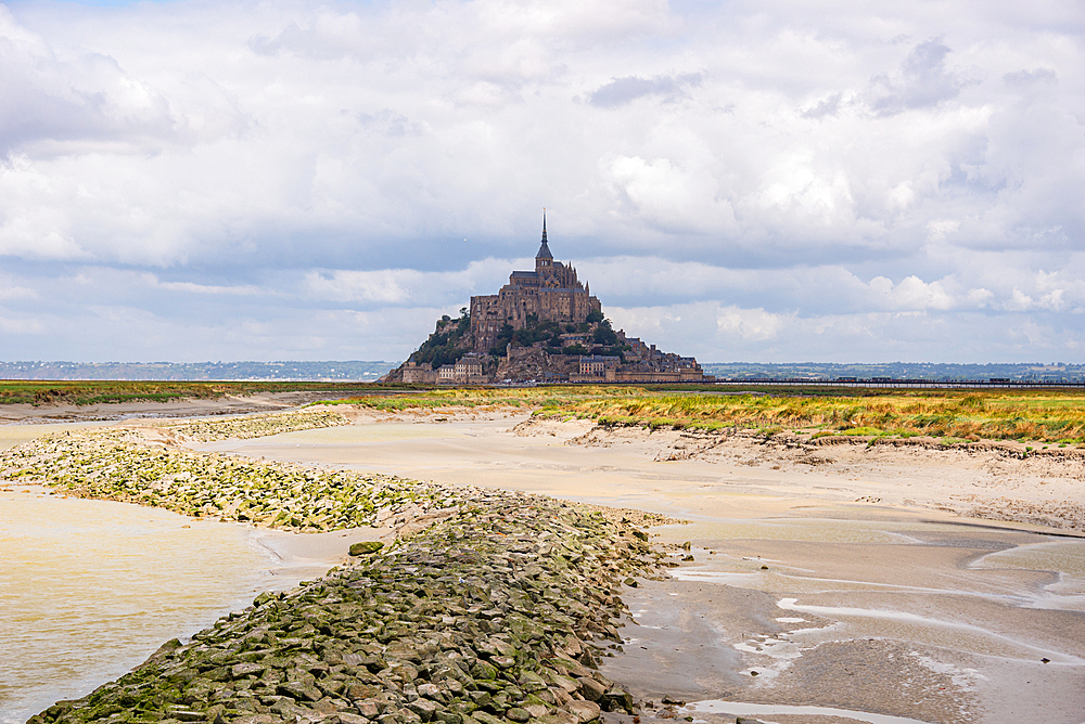 Mont Saint-Michel seen across sandy tidal channels at low tide, Normandy, France