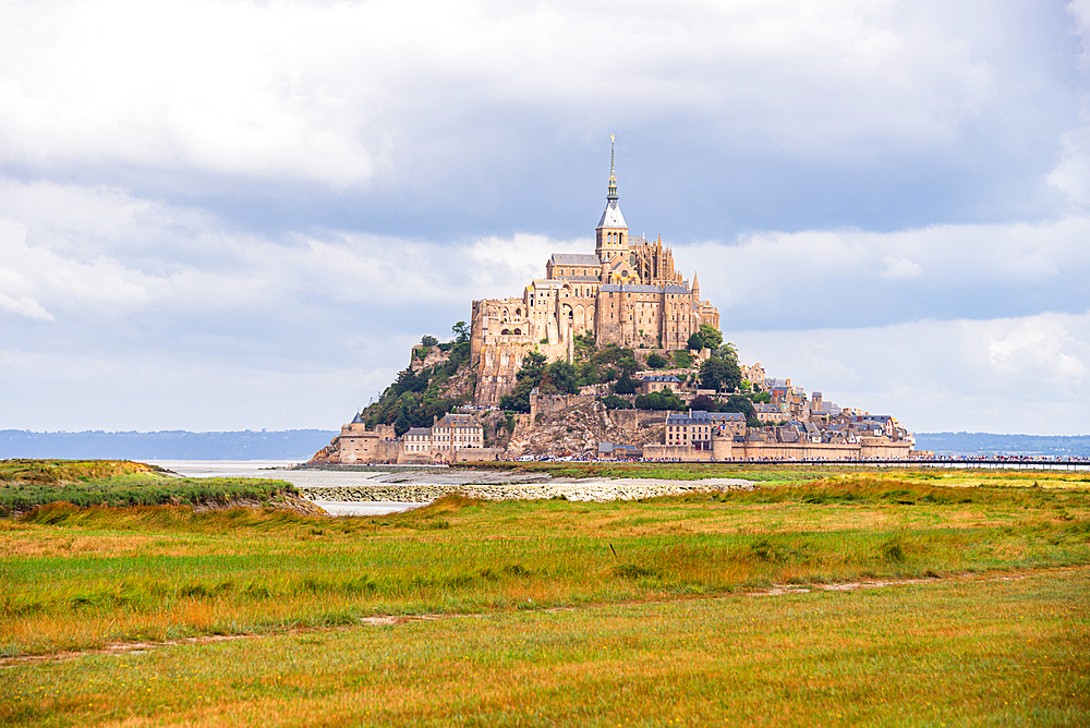 Side view of Mont Saint-Michel Abbey standing on its rocky island above the surrounding tidal flats, Normandy, France