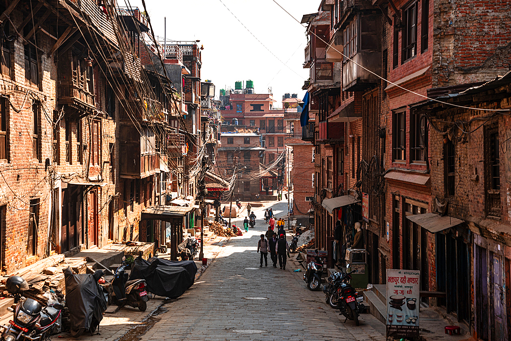 View along a pedestrian road with traditional brick houses in the center of Bhaktapur, Kathmandu, Nepal, Asia