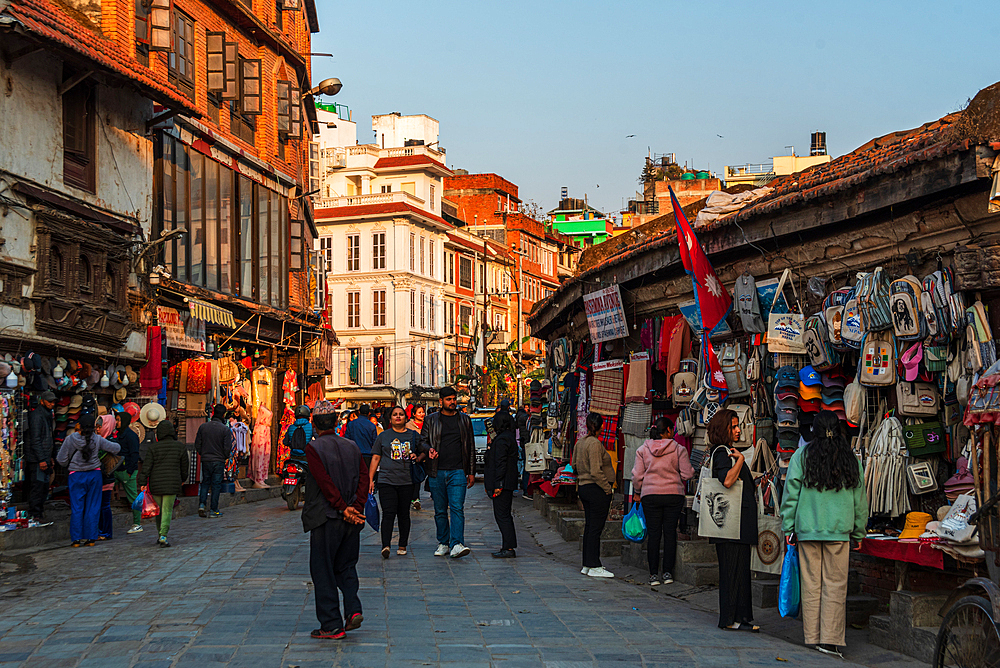 Shops of hemp backpacks and visitors in the streets around the historic centre at sunset, Durbar Square, Kathmandu, Nepal, Asia