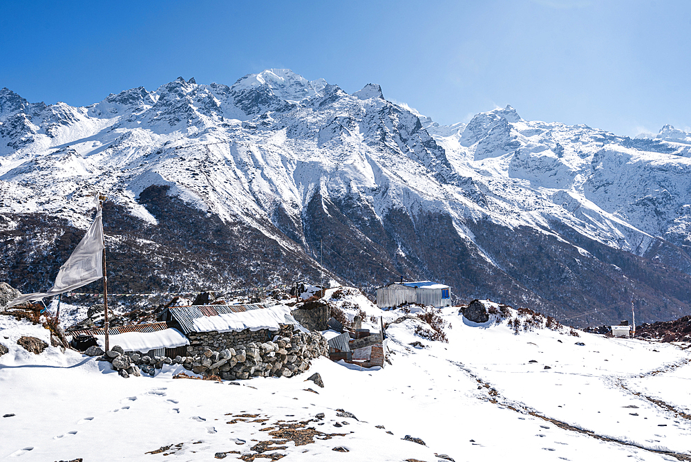 Stone walls in the snows and snowy mountain range, Kyanjin Gompa, Langtang Valley trek, Himalayas, Nepal, Asia