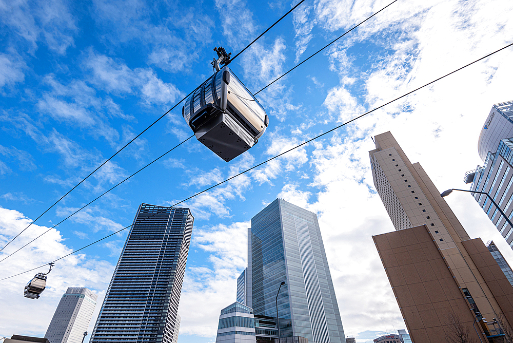 Yokohama Air Cabin (Ropeway) against a blue sky and towering skyscrapers, Tokyo, Honshu, Japan, Asia