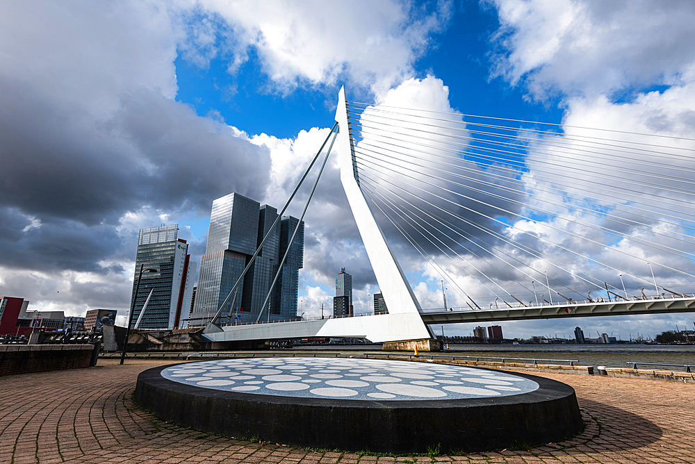 Impressive Erasmus bridge in Rotterdam harbor with dramatic sky and art in the foreground, Rotterdam, The Netherlands, Europe