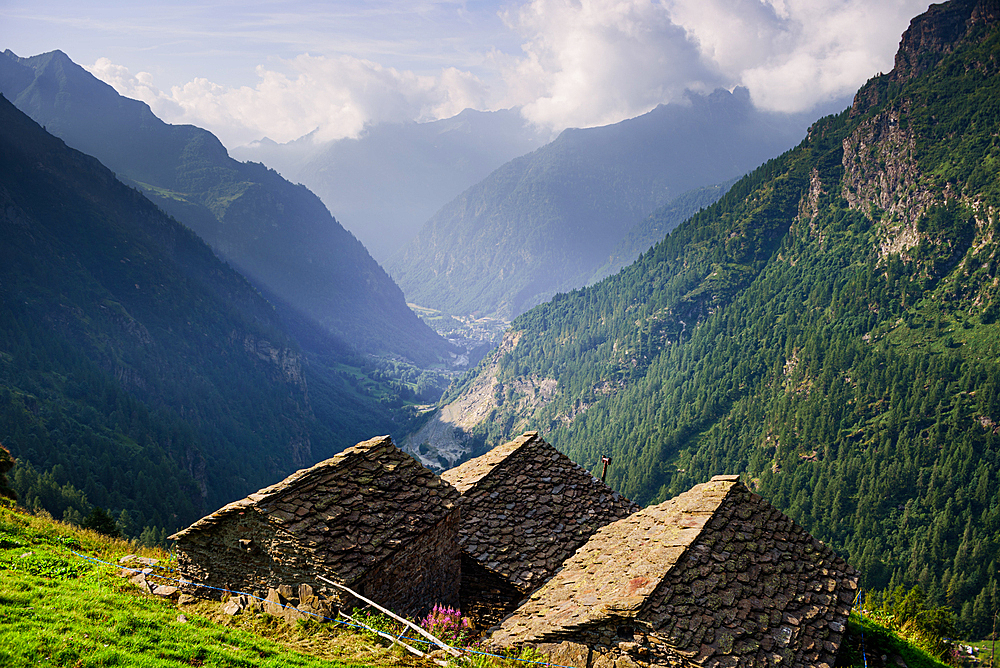 Nature Park Valsesia and the Alta Val Strona with view over the valley with stone roof tops of traditional huts in the foreground, Piedmont, Italian Alps, Italy, Europe