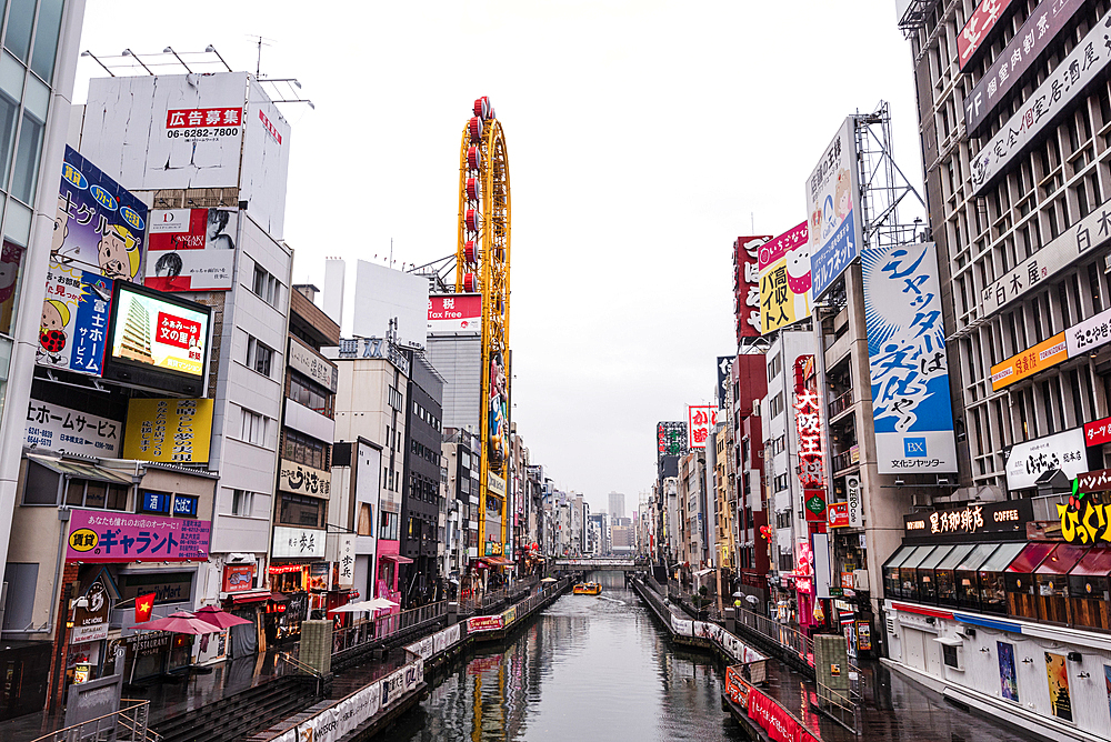 View along the channels, walking paths and bridges along Dotonbori River in Osaka. Overcast day