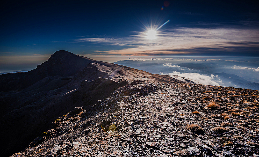 Dramatic rocky mountain ridge of th Sierra Nevada. With Cerro del Caballo against the sun. Spain