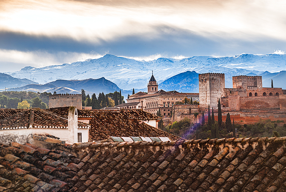 albaycin roof tops, Alhambra and snowy mountains in Granada, Spain. First snow in Autumn in the Sierra Nevada behind Alhambra, Granada