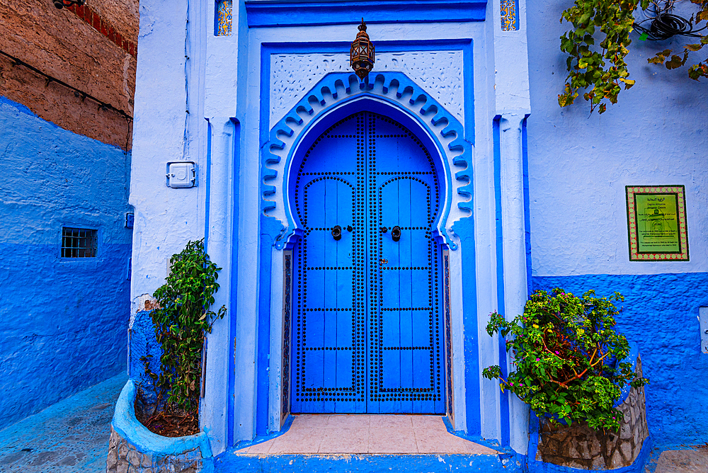 Beautiful decorated blue entrance door in the blue colored streets of Chefchaouen, Morocco