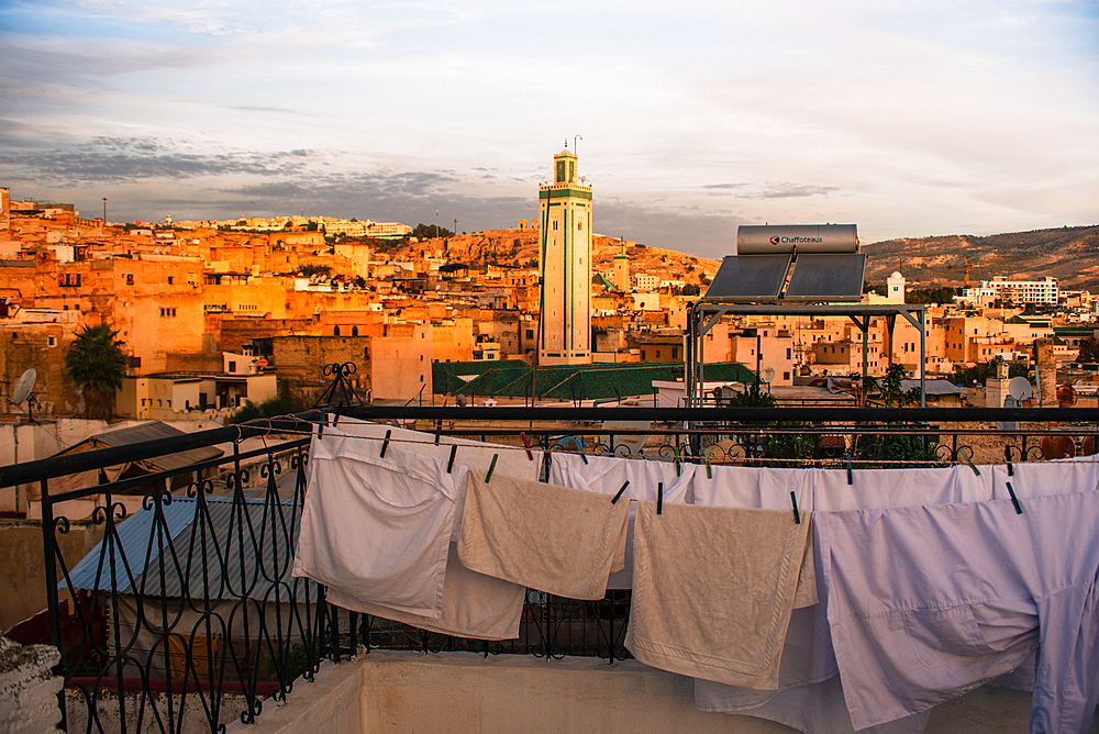 Sunrise in Fes, drying white cloths on a clothing line. Medina old town with Kairaouine Mosquein the background. Morocco, Fes