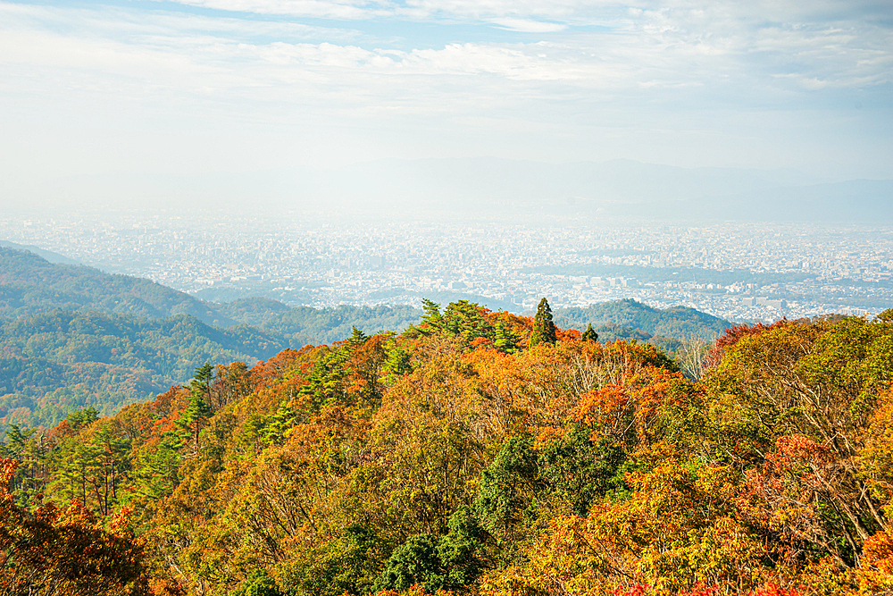 A breathtaking view of forested mountains with autumn colors and distant hills. View from Mount Hiei, Hiei San, Kyoto area