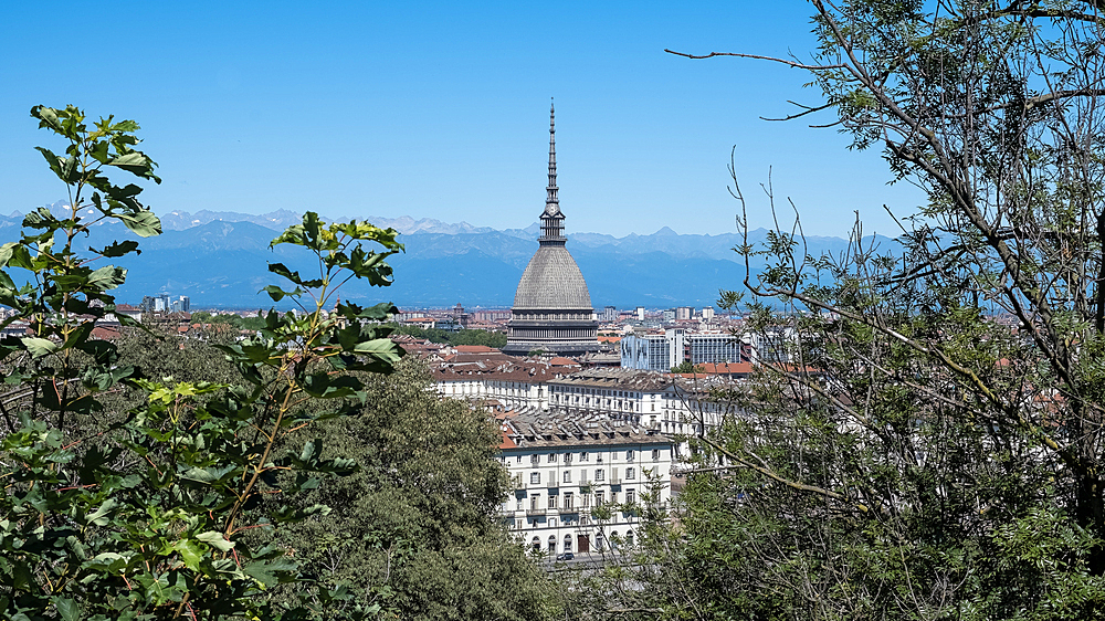 Cityscape of Turin, Italy, featuring the iconic Mole Antonelliana building that stands out among the city's skyline. This landmark is named after its architect, Alessandro Antonelli. In Italian, a “mole” refers to a building of monumental proportions.