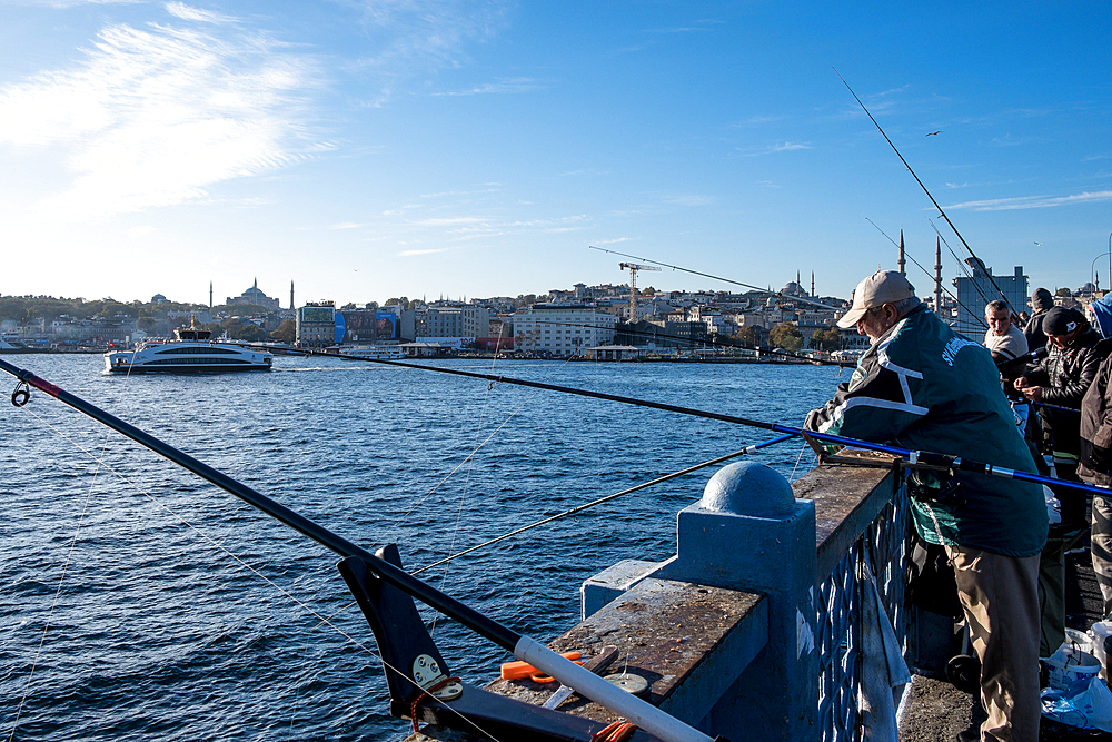 Fishermen at the famous Galata Bridge, a bridge spanning the Golden Horn, Istanbul, Turkey, Europe