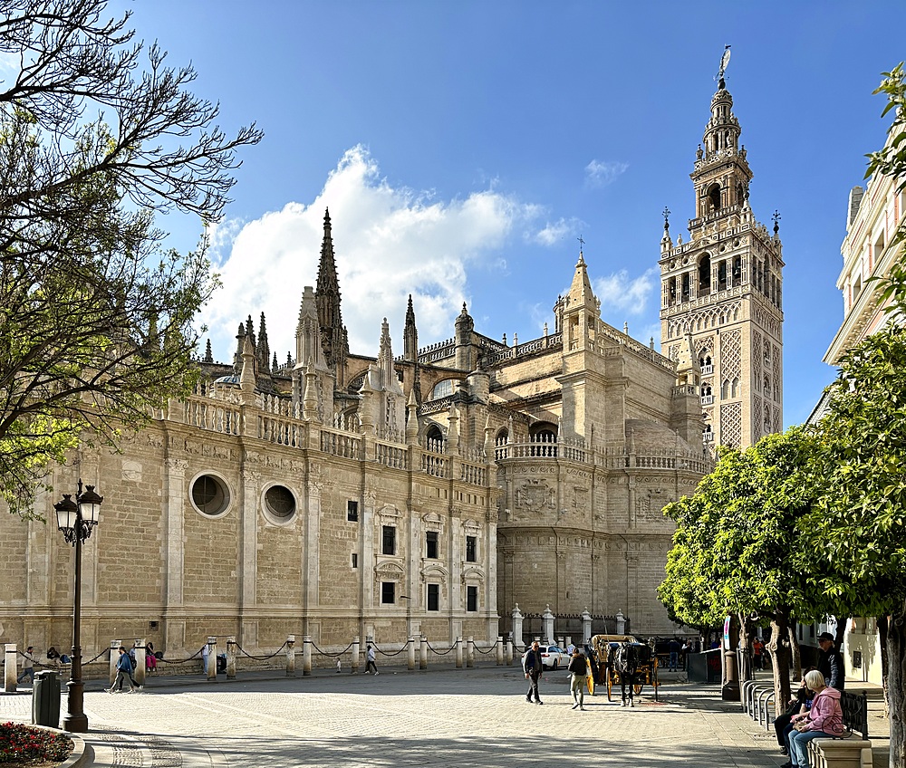 View of the Cathedral of Saint Mary of the See (Seville Cathedral), a Roman Catholic cathedral in Seville, one of the largest churches in the world as well as the largest Gothic church, highlighting the Giralda, the bell tower of the cathedral.