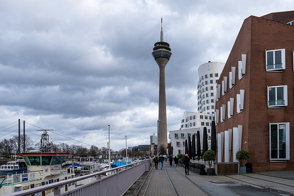 View of the Neuer Zollhof (The New Zollhof), named after a former customs facility, a prominent landmark of Dusseldorf-Hafen, part of the redeveloped port of Dusseldorf,  with the Rheinturm (Rhine Tower) telecommunications tower in the background, Dusseldorf, North Rhine Westphalia, Germany, Europe