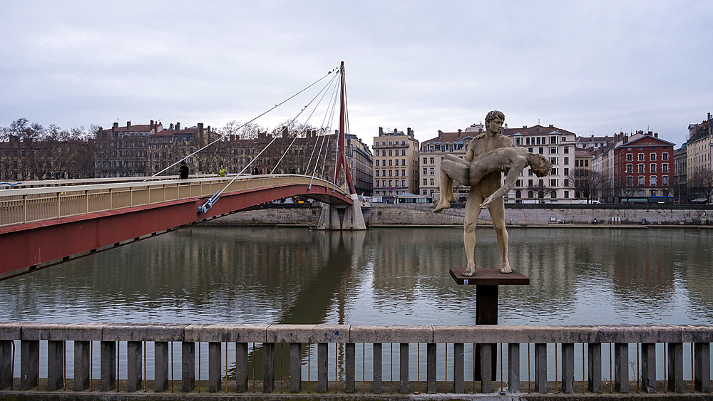 Cityscape of the city of Lyon in France from the riverside of the Saone River with the The Weight of Oneself sculpture in the foreground in front of the courthouse, Lyon, Auvergne Rhone Alpes, France, Europe