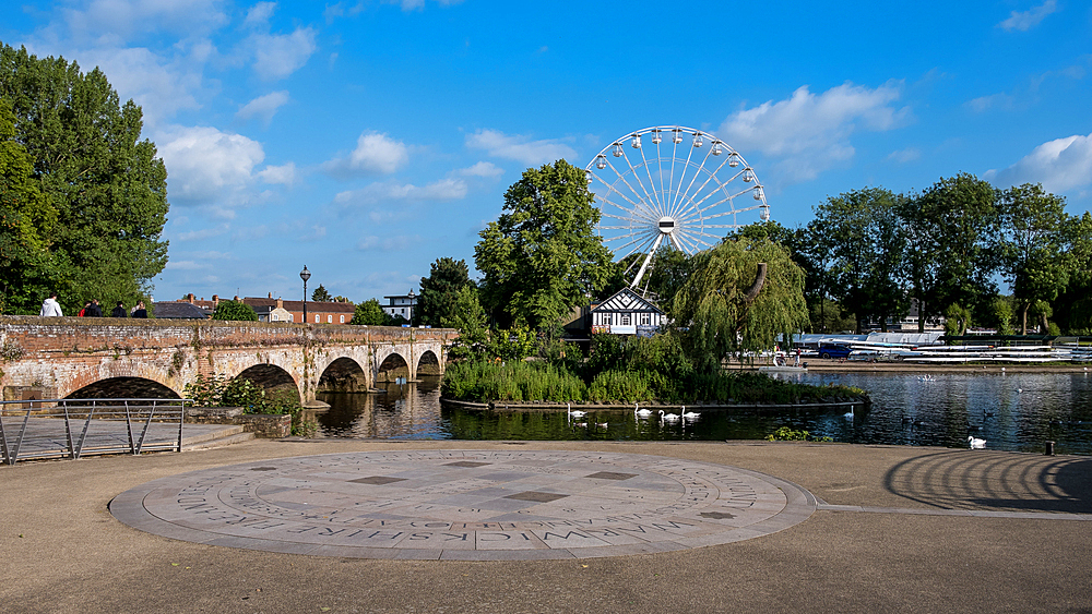 Scenic view of the River Avon in Stratford-upon-Avon, England, on a sunny day with the historic Clopton Bridge in the background. This Late Medieval masonry arch bridge spans the river and is Grade I listed, adding to the charm of this iconic market town.