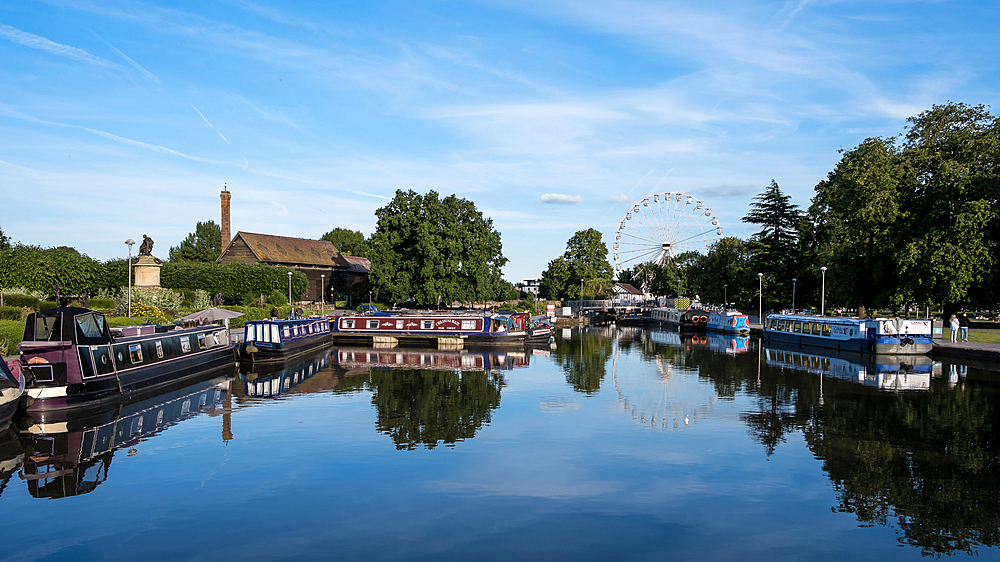 Scenic view of Bancroft Basin in Stratford-upon-Avon, England, on a sunny day. This picturesque basin by the River Avon is a vibrant hub for narrowboats and leisure activities, adding charm to the historic town known as Shakespeare's birthplace.