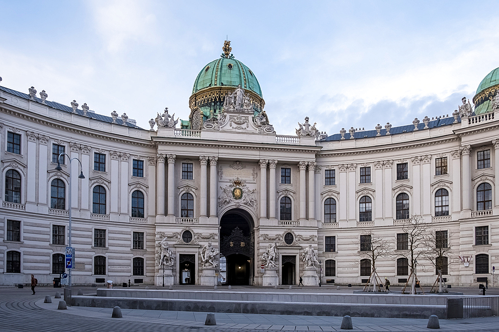Vienna, Austria – View of St. Michael's Wing at Michaelerplatz, the grand Baroque facade of Hofburg Palace's entrance with its monumental dome and sculpted imperial eagles overlooking the square.