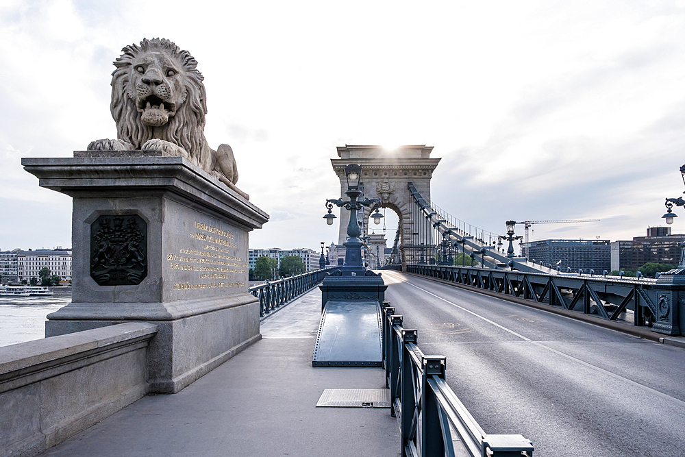 Budapest, Hungary – View of one of the stone lions guarding the entrance to the Chain Bridge, a 19th-century suspension bridge linking Buda and Pest across the Danube River.