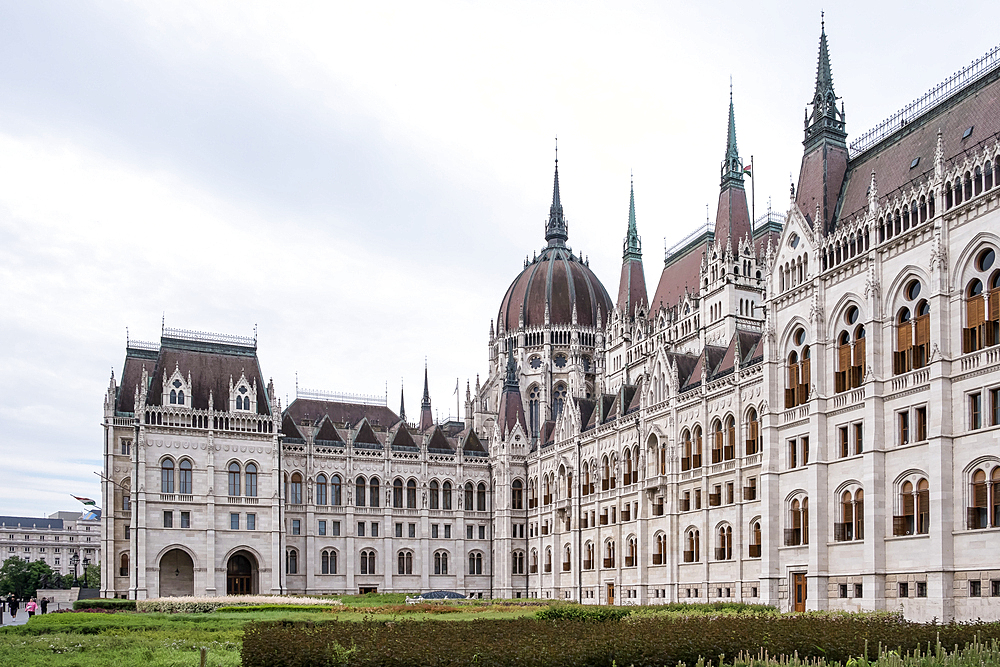 Budapest, Hungary – Architectural detail of the Hungarian Parliament Building, showcasing its Neo-Gothic façade with ornate spires, arched windows, and sculpted figures that reflect Hungary’s medieval heritage and national symbolism.