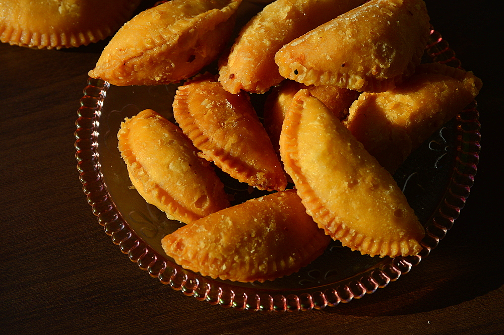 A gujiya (pedakiya) (gughara karanji) (somas karjikayi) (bakru), a sweet deep fried dumpling on a plate, India, Asia