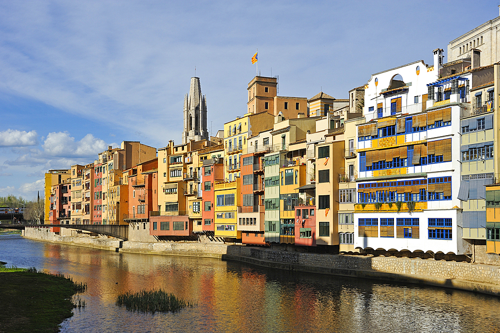 front of the houses, among which the white Casa Maso, birthplace of the Catalan architect Rafael Masó (1880-1935), by the Onyar River, with the tower bell of Collegiate Church of San Felix in the background, Girona, Catalonia, Spain,Europe