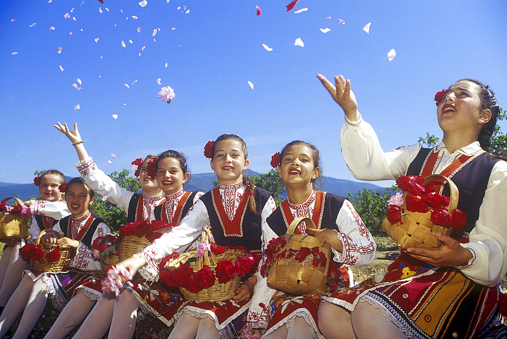 Traditional dressed young girls in a rose garden during the Rose Festival in the Rose Valley, Kazanlak, Bulgaria, Europe