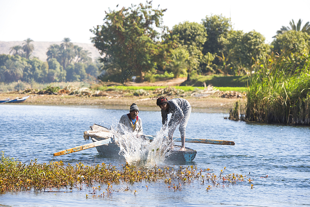 Net fishermen in rowing boat practising a technique of hitting the surface of the water to drive fish into the nets, village of Ramadi, west bank of the Nile south of Edfu, Egypt, North Africa, Africa