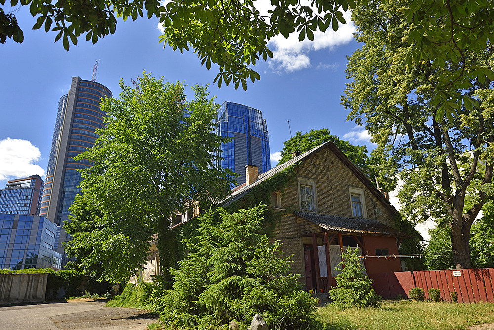 Old houses surrounded by modern office towers in the Snipiskes district, Vilnius, Lithuania, Europe