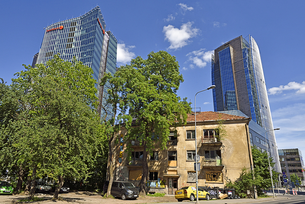 Old houses surrounded by modern office towers in the Snipiskes district, Vilnius, Lithuania, Europe