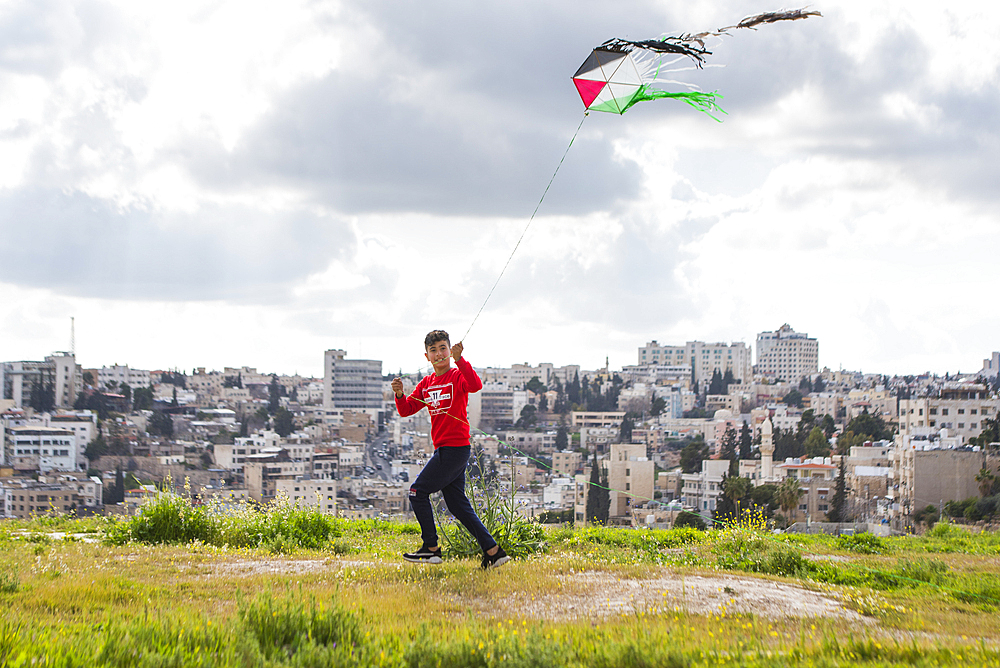 Young boy flying a kite in the enclosure of the Amman Citadel (Jabal al-Qal'a), historic site located on top of a hill in the heart of Amman,  Jordan, Middle East