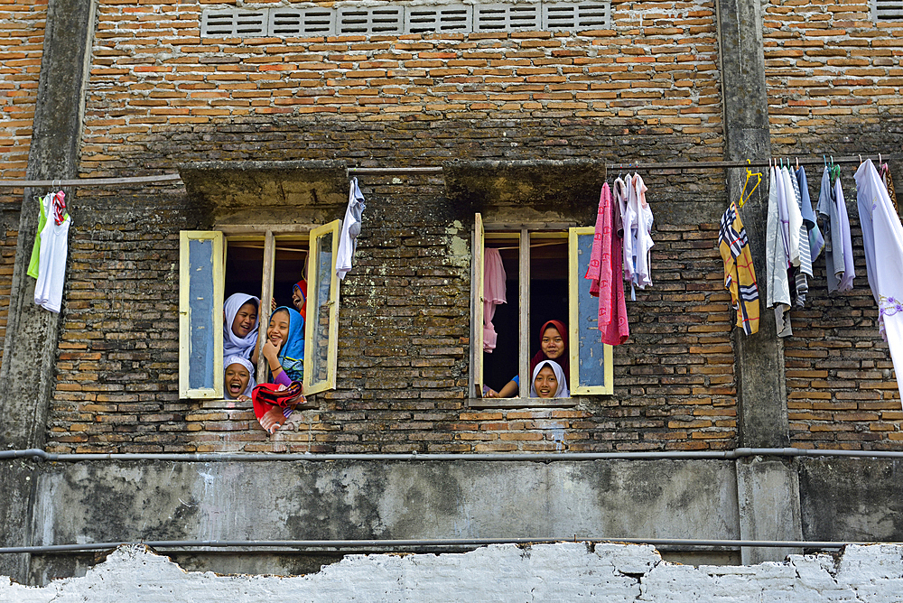 School girls at the window of a high school dormitory, Lasem, Java island, Indonesia, Southeast Asia, Asia