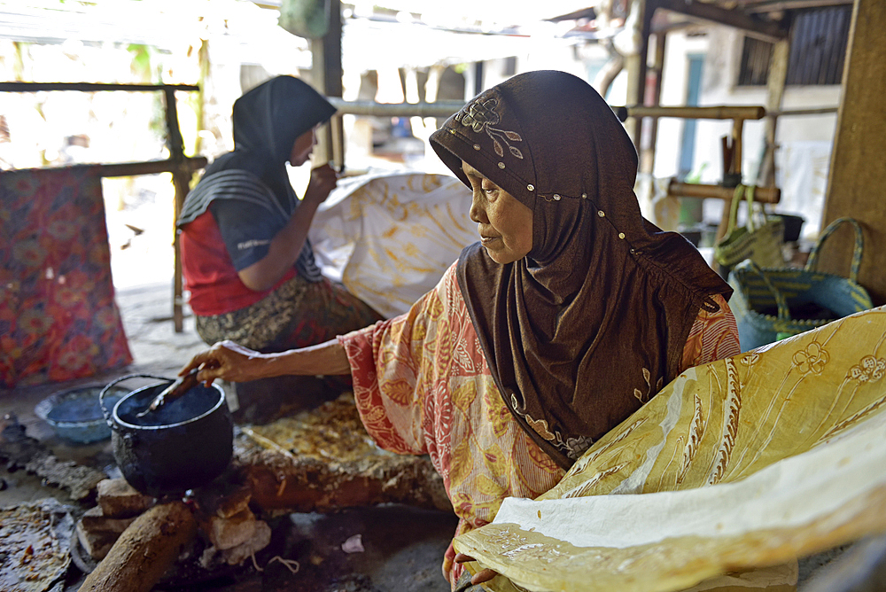 women using a pen-like tool, called 'canting', to apply liquid hot wax to create directly pattern on the fabric without preliminary drawing, Nyah Kiok batik house, craft production by seven women for over 30 years, Lasem, Java island, Indonesia, Southeast