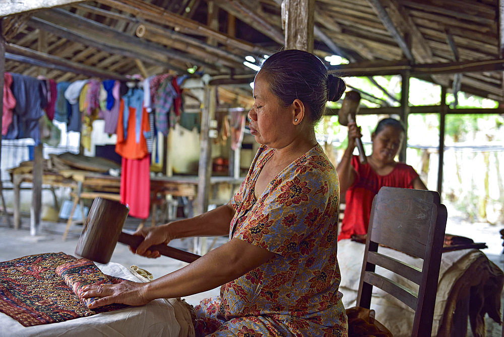 Woman using a mallet to fold batik fabric, Nyah Kiok batik house, craft production by seven women for over 30 years, Lasem, Java island, Indonesia, Southeast Asia, Asia